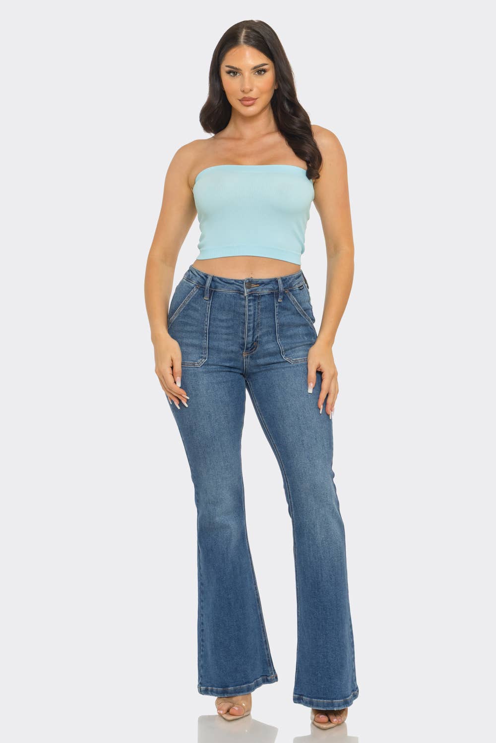 Model wearing a Strapless ribbed bandeau crop top paired with high-waisted flared jeans.